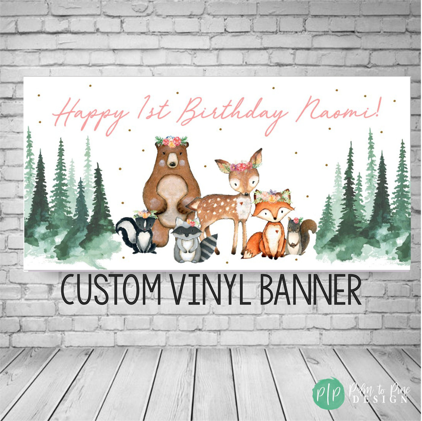 A white custom vinyl banner with a woodland theme. The banner features a brown bear, a deer, a fox, a raccoon, and a skunk. The banner also features green pine trees and gold glitter.