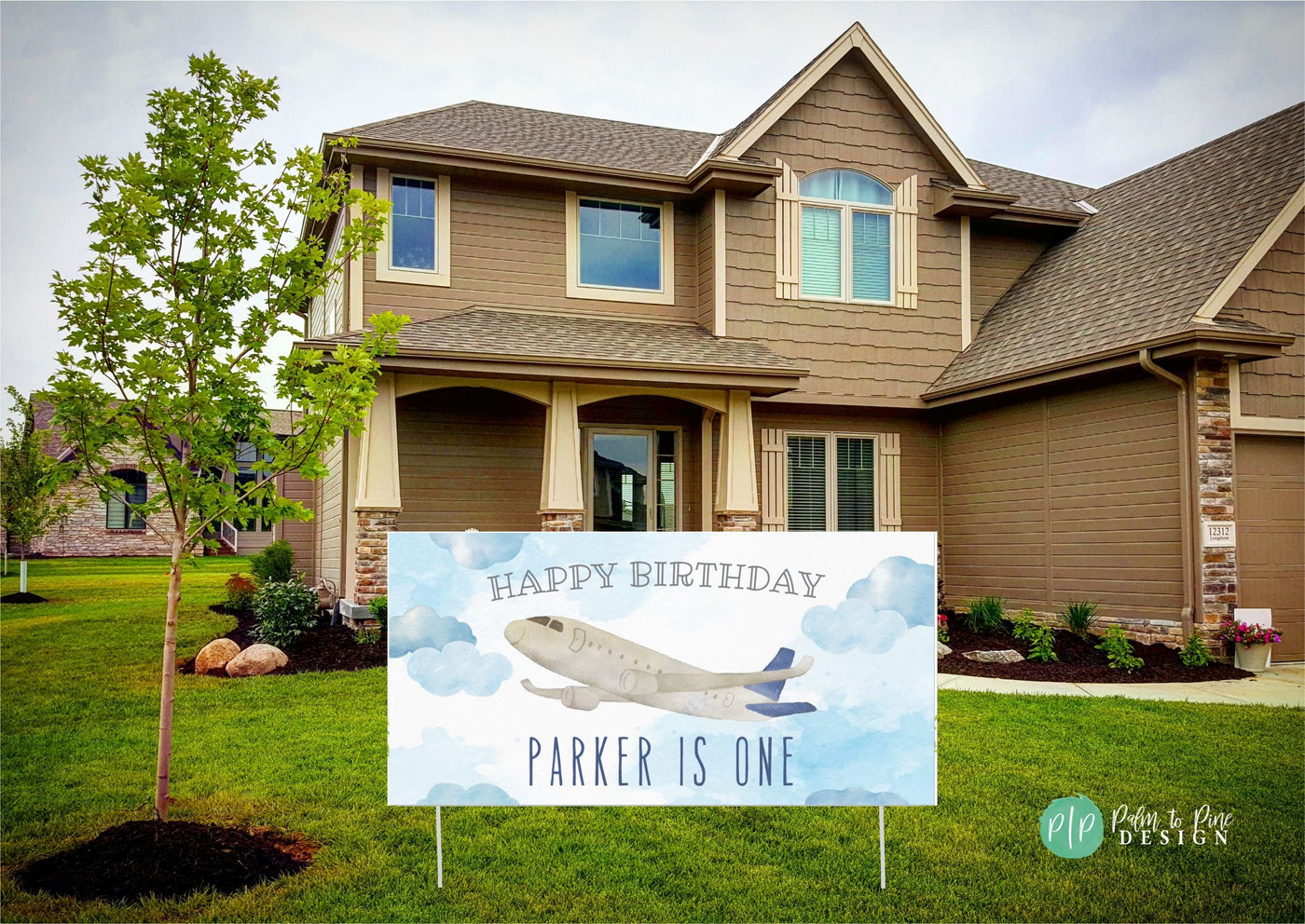 A blue and white birthday sign with an airplane flying through clouds. The sign reads &#39;Happy Birthday Parker is One&#39;