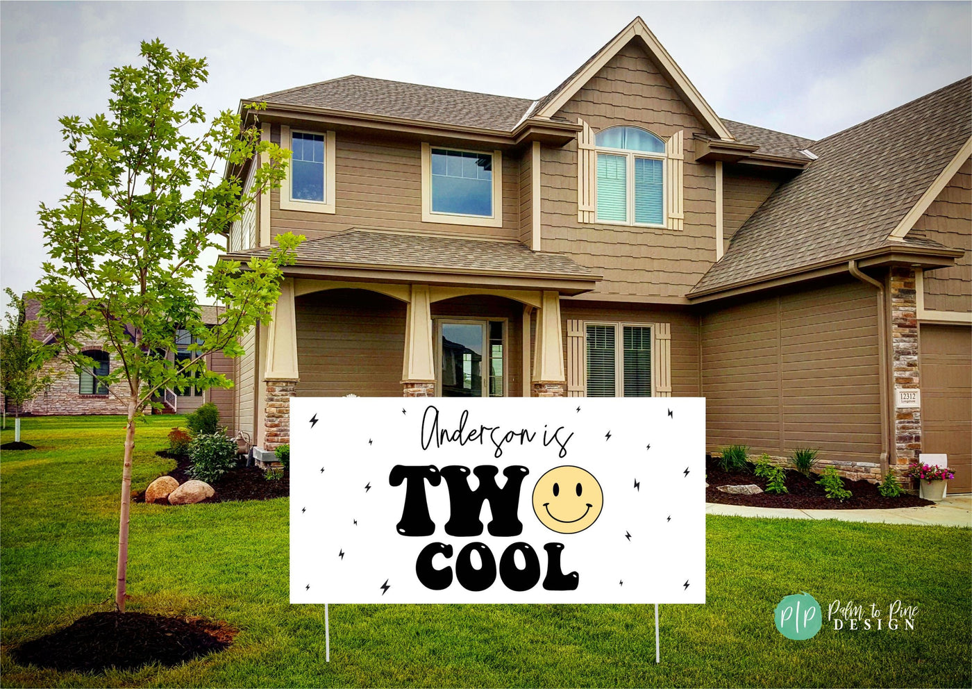 A fun and vibrant &#39;Two Cool&#39; birthday banner featuring a yellow smiley face and striking lightning bolt details in the front yard of a house