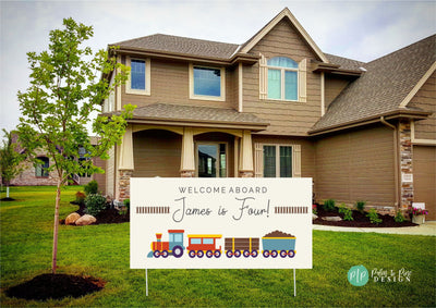 Modern train-themed birthday banner with a light tan backdrop, showcasing colorful red, yellow, and blue train clipart and simple railroad track illustrations in the front yard of a house