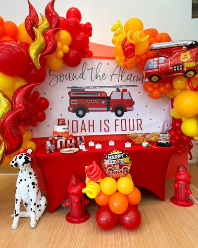 Firefighter birthday party set up with personalized banner and fire balloon arches