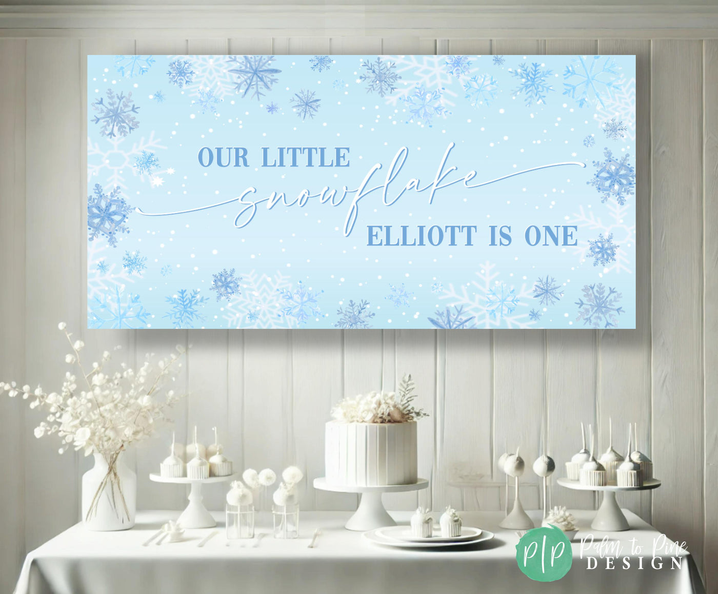 snowy white winter onederland birthday dessert table with custom blue snowflake banner