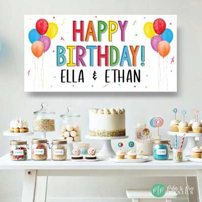 Custom happy birthday banner in bold rainbow colors, featuring a cheerful font for kids&#39; or adults&#39; parties in front of a dessert table